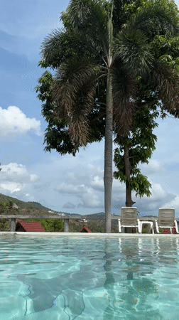 Woman films poolside content in Thailand daytime