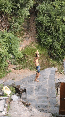 Man prepares platform jump in Dharamkot woods during morning