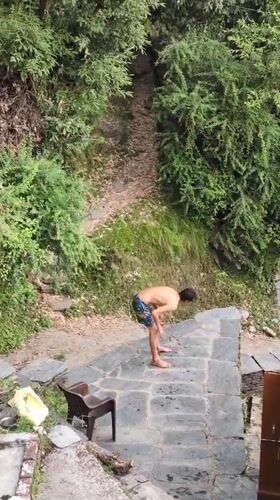 Man prepares platform jump in Dharamkot woods during morning