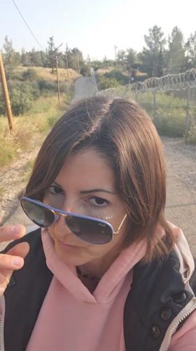 Woman takes selfies on rural road in Lachish, Israel