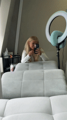 Woman takes mirror selfie at beauty salon
