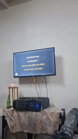 Woman performs karaoke at indoor venue in La Tagua, Venezuela