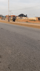 Motorcyclist observed traveling on asphalt road in Bukuru, Nigeria