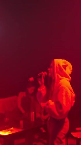 Woman performs in red-lit venue in Baan Bang Rak