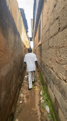 Man walks through narrow alley in Jos, Nigeria