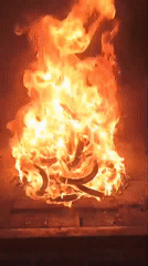 Large fire burns on stone surface, captured on video