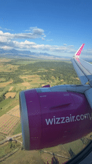 Passenger films Wizz Air's pink branding from airplane window over Montenegro