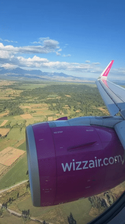 Passenger films Wizz Air's pink branding from airplane window over Montenegro