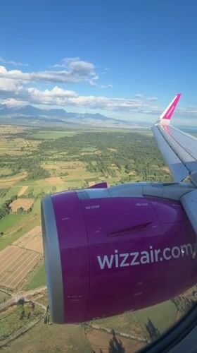 Passenger films Wizz Air's pink branding from airplane window over Montenegro