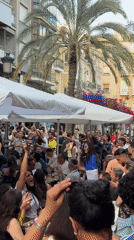 Outdoor crowd celebrates while watching soccer match at cafe