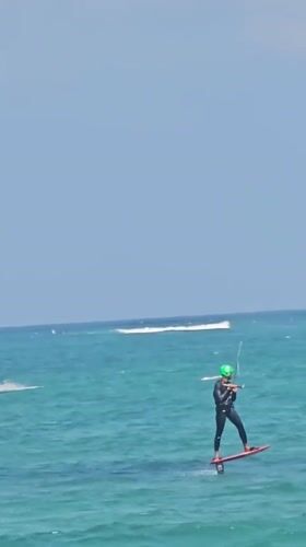 Kiteboarders and colorful kites fill Denpasar's coastal waters