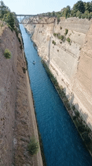 Corinth Canal on a clear July afternoon, sailboat passing through