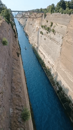 Corinth Canal on a clear July afternoon, sailboat passing through
