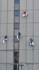 Facade workers rappel down Moscow high-rise on summer morning