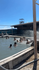 Adults enjoy sunny day swimming in Zhemchug pool