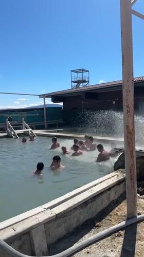 Adults enjoy sunny day swimming in Zhemchug pool