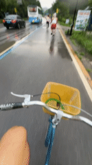 Cyclists ride through rainy Guilin countryside amid karst mountains