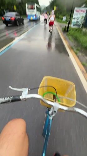 Cyclists ride through rainy Guilin countryside amid karst mountains