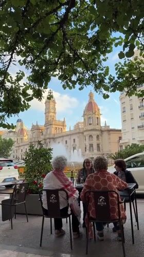Women gather at Valencia cafe on palm-lined street