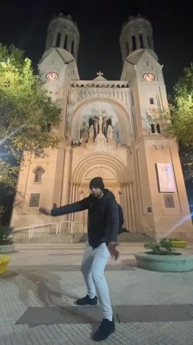 Person stands before illuminated Buenos Aires basilica at night