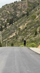 Horseback rider travels mountain road in rural Kyrgyzstan