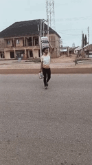 Morning street activity in Bukuru shows pedestrians carrying goods