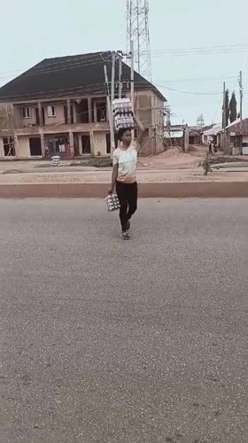 Morning street activity in Bukuru shows pedestrians carrying goods