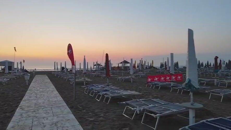 Empty Rimini beach at golden hour, chairs and umbrellas at rest
