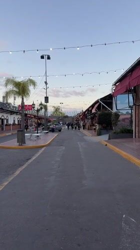 String lights and red awnings along a Tigre street at night