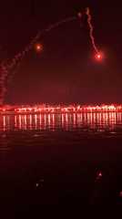 Fireworks and flares illuminate Rijeka's harbor at night