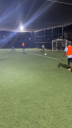 Nighttime soccer match played on enclosed turf field in Nigeria