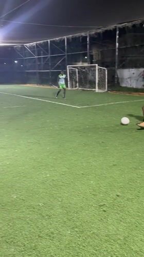 Nighttime soccer match played on enclosed turf field in Nigeria