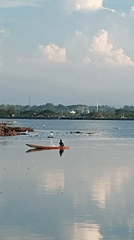 Kayaker paddles calm waters near Lhokseumawe, Indonesia