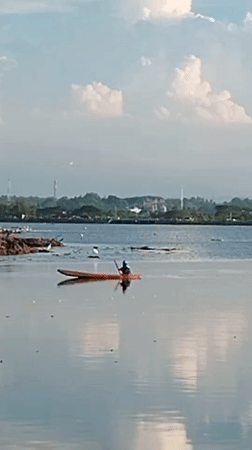 Kayaker paddles calm waters near Lhokseumawe, Indonesia