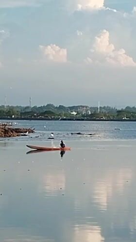 Kayaker paddles calm waters near Lhokseumawe, Indonesia