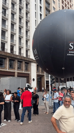 Street gathering features large black balloon in São Paulo
