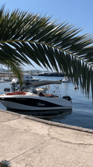 White speedboat docked in calm Tivat marina, Montenegro
