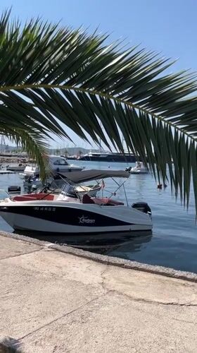 White speedboat docked in calm Tivat marina, Montenegro