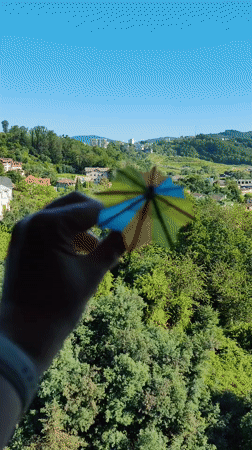 Cocktail umbrella held up against Sochi's sunny green hillside