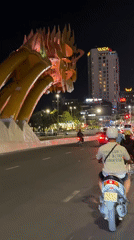Nighttime ride past Đà Nẵng's glowing Dragon Bridge sculpture