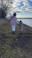 Woman and child walk lakeside in Votkinsk, Russia