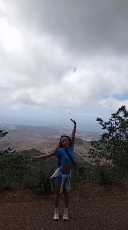 Woman photographed at scenic Las Piedras overlook above coastal city