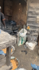 Agricultural workers mix animal feed at Jos market