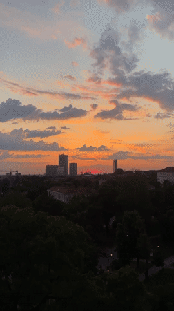 Vibrant sunset with crescent moon observed over Belgrade district