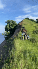 Dirt bike rider navigates hillside overlooking Volga River
