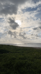 Woman walks coastal path in Kuta Selatan during cloudy evening