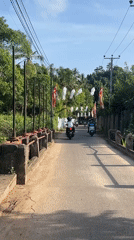 Motorbikes travel decorated road near Heenatigala Junction, Sri Lanka