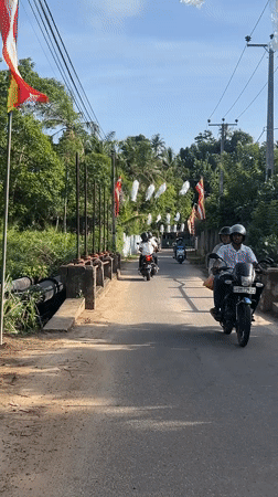 Motorbikes travel decorated road near Heenatigala Junction, Sri Lanka
