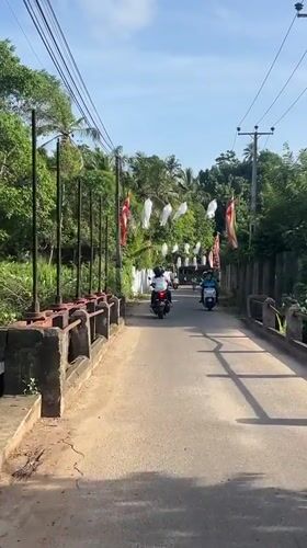 Motorbikes travel decorated road near Heenatigala Junction, Sri Lanka