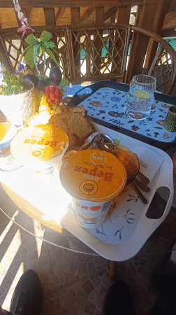 Two people enjoy outdoor breakfast at glass table
